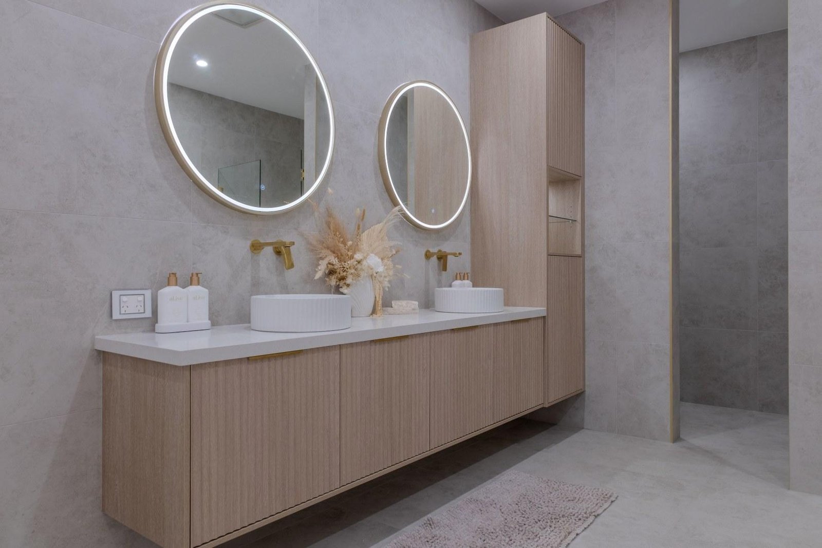 Fluted timber double vanity with brass tapware and stone tiling, bathroom renovation in Mosman, Sydney
